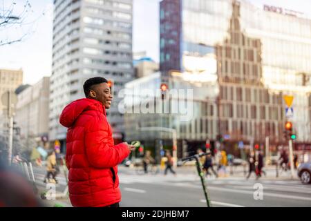Jeune homme utilisant un smartphone à l'extérieur en milieu urbain Banque D'Images