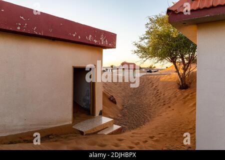 Des bâtiments résidentiels abandonnés enterrés dans le sable dans le village fantôme d'Al Madame à Sharjah, Émirats arabes Unis. Banque D'Images