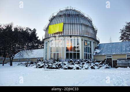 Bâtiment avec toit bombé dans la neige. Serre avec de belles fenêtres avec des reflets Banque D'Images