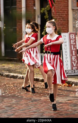 Les adolescentes effectuent une danse de Noël en portant des masques dans le quartier historique de Newburyport, Massachusetts, États-Unis, en décembre 2020. Banque D'Images