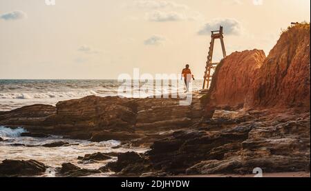 Femme africaine marchant sur la plage pendant le coucher du soleil à Accra Ghana Afrique de l'Ouest Banque D'Images