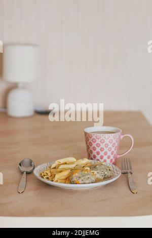 Vue sur le petit déjeuner. Des côtelettes de viande faites maison avec des pâtes et une tasse de café Banque D'Images