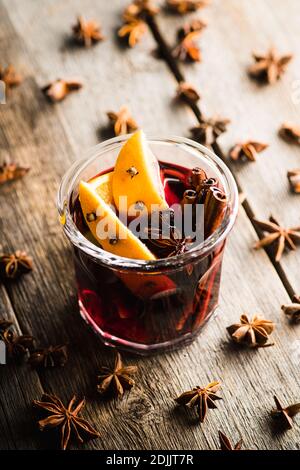 Vin rouge chaud accompagné d'oranges et de différentes épices en verre sur fond rustique. Repas de Noël. Décorations d'hiver. Mise au point sélective. Rayon peu profond Banque D'Images