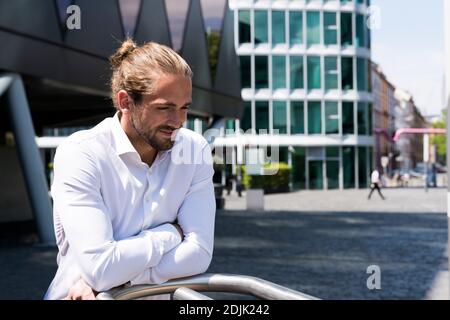 young man with man bun out and about in the city Stock Photo