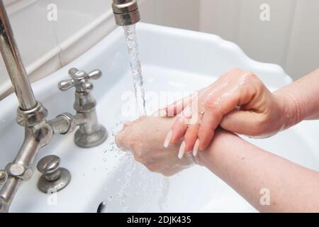 Femme se laver les mains à l'eau courante Banque D'Images