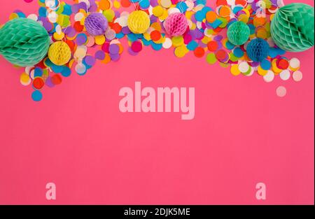 beaucoup de confettis colorés sur un fond rose isolé. La vue du dessus. Banque D'Images