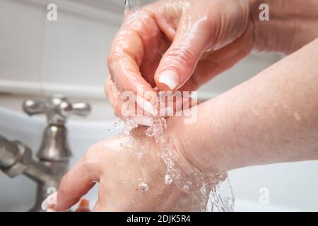 Femme se laver les mains à l'eau courante Banque D'Images