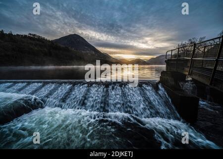 Un beau lever de soleil d'hiver sur une matinée calme au puissant déversoir de Crummock Water. Lake District, Cumbria, Angleterre Banque D'Images