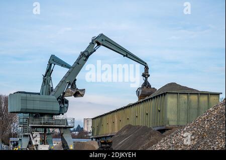 Grande pelle hydraulique manipulant des cailloux de la pile de pierres au conteneur. Machine en chantier. Industrie. Banque D'Images