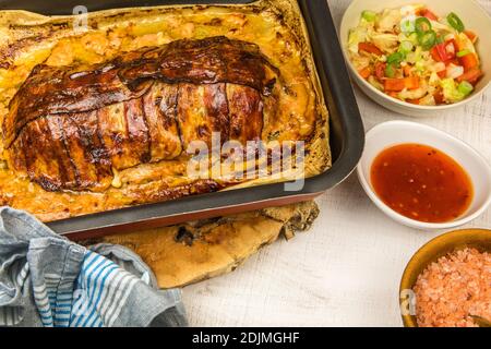 Viande hachée au four avec épices au Chili et saucisses. Fabrication d'un pain de viande classique avec du bœuf haché. Délicieux pain de dinde cuit avec bacon sur une planche de bois. Banque D'Images