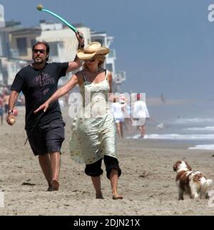 Rosanna Arquette fait une promenade sur la plage avec un ami tout en jouant à FETCH avec quelques chiens. Peut-être l'actrice est-elle consciente de la portée, car elle semble être en fourre-tout un pot de yogourt rempli de sable. Malibu, Calif. 7/9/06 Banque D'Images