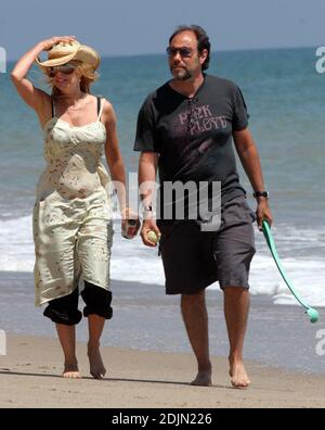 Rosanna Arquette fait une promenade sur la plage avec un ami tout en jouant à FETCH avec quelques chiens. Peut-être l'actrice est-elle consciente de la portée, car elle semble être en fourre-tout un pot de yogourt rempli de sable. Malibu, Calif. 7/9/06 Banque D'Images