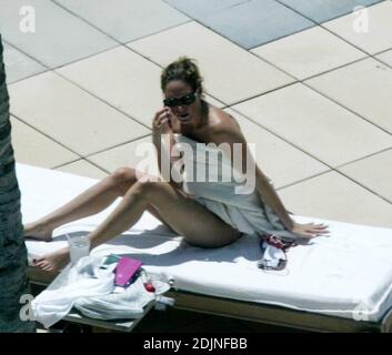 Exclusif !! Thierry Henry, joueur de football de France et d'Arsenal, donne à sa fille des leçons de natation et de contrôle du ballon. La femme Nicole Merry, qui a passé le matin à bronzer, regarda et ressemblait à toute maman fière avec son appareil photo numérique. Le matin, Nicole a pris un bain de soleil en solo pendant une heure et demie chaque jour tout en discutant sans arrêt sur son téléphone mobile, Miami Beach, FL, 7/25/06 Banque D'Images