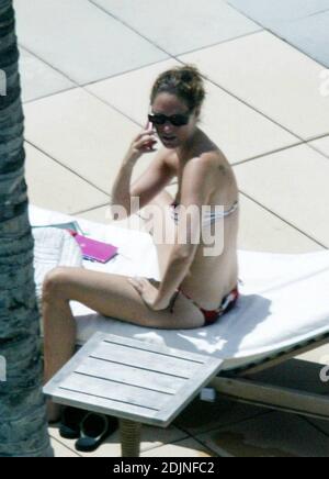 Exclusif !! Thierry Henry, joueur de football de France et d'Arsenal, donne à sa fille des leçons de natation et de contrôle du ballon. La femme Nicole Merry, qui a passé le matin à bronzer, regarda et ressemblait à toute maman fière avec son appareil photo numérique. Le matin, Nicole a pris un bain de soleil en solo pendant une heure et demie chaque jour tout en discutant sans arrêt sur son téléphone mobile, Miami Beach, FL, 7/25/06 Banque D'Images