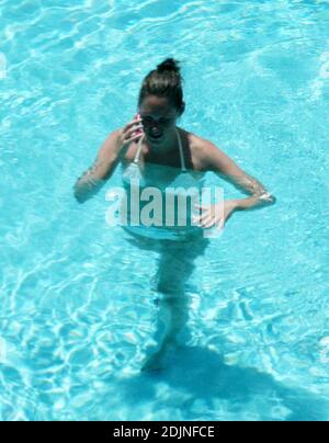 Exclusif !! Thierry Henry, joueur de football de France et d'Arsenal, donne à sa fille des leçons de natation et de contrôle du ballon. La femme Nicole Merry, qui a passé le matin à bronzer, regardait et comme n'importe quelle maman fière s'est emparée de son appareil photo numérique, le matin, Nicole a pris un bain de soleil en solo pendant une heure et demie chaque jour tout en discutant un de son téléphone mobile sans arrêt, Miami Beach, FL, 7/25/06 Banque D'Images