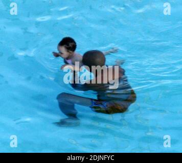 Exclusif !! Thierry Henry, joueur de football de France et d'Arsenal, donne à sa fille des leçons de natation et de contrôle du ballon. La femme Nicole Merry, qui a passé le matin à bronzer, regarda et ressemblait à toute maman fière avec son appareil photo numérique. Le matin, Nicole a pris un bain de soleil en solo pendant une heure et demie chaque jour tout en discutant sans arrêt sur son téléphone mobile, Miami Beach, FL, 7/25/06 Banque D'Images