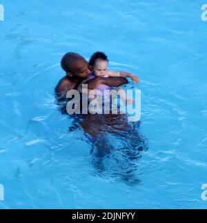 Exclusif !! Thierry Henry, joueur de football de France et d'Arsenal, donne à sa fille des leçons de natation et de contrôle du ballon. La femme Nicole Merry, qui a passé le matin à bronzer, regarda et ressemblait à toute maman fière avec son appareil photo numérique. Le matin, Nicole a pris un bain de soleil en solo pendant une heure et demie chaque jour tout en discutant sans arrêt sur son téléphone mobile, Miami Beach, FL, 7/25/06 Banque D'Images