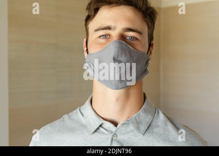 Portrait d'un homme caucasien portant un masque gris qui regarde droit vers l'appareil photo Banque D'Images