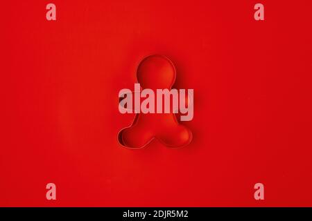 plat avec emporte-pièce hommes pain d'épice sur fond rouge. Banque D'Images