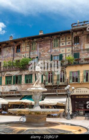 Vérone, province de Vérone, Vénétie, Italie. Les magnifiques fresques d'Alberto Cavalli sur les maisons de Mazzanti et la fontaine avec la statue de Madonna di Verona Banque D'Images