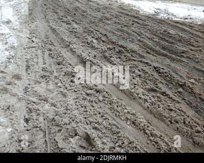 Porridge of snow and grease on the road. Uncleared city roads in winter. Stock Photo