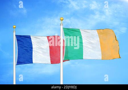 France et Irlande deux drapeaux sur les mâts et bleu nuageux ciel Banque D'Images