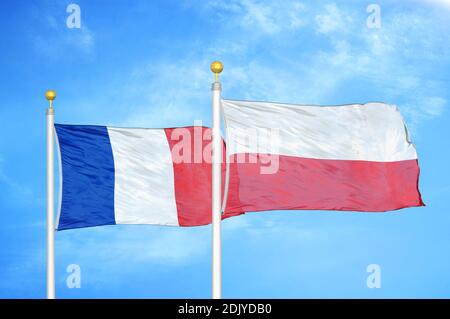 France et Pologne deux drapeaux sur les mâts et bleu nuageux ciel Banque D'Images