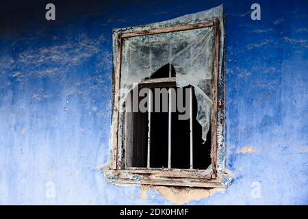 Mur bleu avec ancienne fenêtre . Maison abandonnée en ruines Banque D'Images