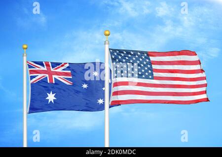 Australie et États-Unis deux drapeaux sur les mâts et le bleu ciel nuageux Banque D'Images