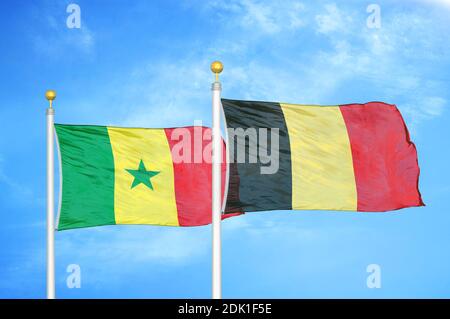 Sénégal et Belgique deux drapeaux sur les mâts de drapeaux et bleu nuageux ciel Banque D'Images