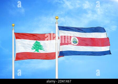 Lebanon and Costa Rica two flags on flagpoles and blue cloudy sky Stock Photo