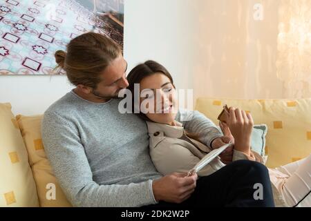 jeune couple avec masque de bouche et de nez sur le canapé Banque D'Images