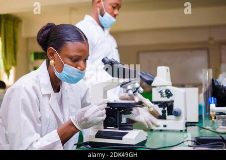 deux jeunes chercheurs africains en soins de santé travaillant dans un laboratoire de sciences de la vie sur la guérison de l'épidémie dans la société. Banque D'Images