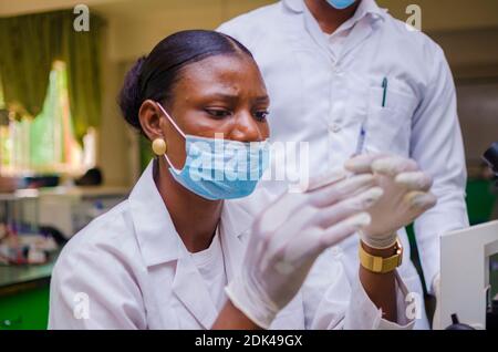 deux jeunes chercheurs africains en soins de santé travaillant dans un laboratoire de sciences de la vie sur la guérison de l'épidémie dans la société. Banque D'Images