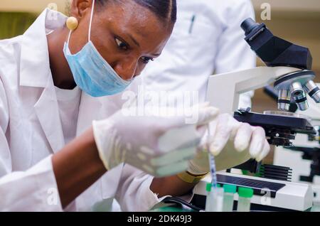 deux jeunes chercheurs africains en soins de santé travaillant dans un laboratoire de sciences de la vie sur la guérison de l'épidémie dans la société. Banque D'Images