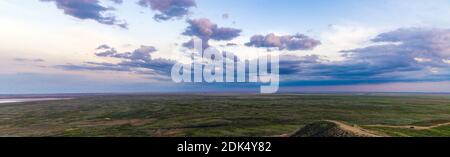 Coucher de soleil pittoresque avec des nuages dans le ciel dans la steppe. Banque D'Images