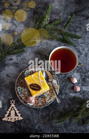 Photo du nouvel an d'un gâteau au thé, kumquat séché sur une table avec des branches de sapin et des jouets, carte postale. Banque D'Images