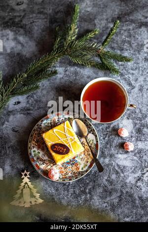 Photo du nouvel an d'un gâteau au thé, kumquat séché sur une table avec des branches de sapin et des jouets, carte postale. Banque D'Images