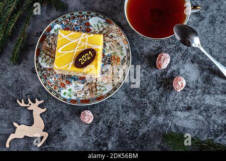 Photo du nouvel an d'un gâteau au thé, kumquat séché sur une table avec des branches de sapin et des jouets, carte postale. Banque D'Images