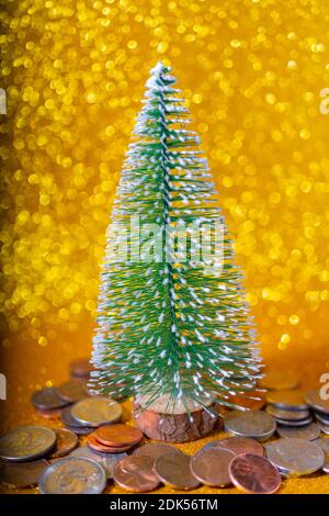 A vertical shot of a Christmas tree and metallic American cents, storage and accumulation of money in the financial system of banks and loans concept Stock Photo