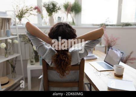 Vue arrière de la femme de créateur reposant sur une chaise dans le studio Banque D'Images