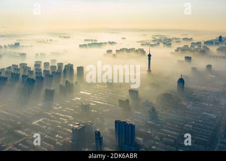 Les nuages d'advection s'écoulent lentement entre les bâtiments urbains, se profilant comme un parc d'expositions dans la ville de Shijiazhuang, province du Hebei au nord de la Chine, 12 décembre Banque D'Images