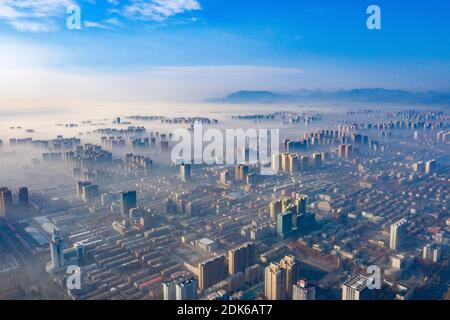 Les nuages d'advection s'écoulent lentement entre les bâtiments urbains, se profilant comme un parc d'expositions dans la ville de Shijiazhuang, province du Hebei au nord de la Chine, 12 décembre Banque D'Images