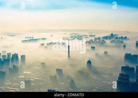 Les nuages d'advection s'écoulent lentement entre les bâtiments urbains, se profilant comme un parc d'expositions dans la ville de Shijiazhuang, province du Hebei au nord de la Chine, 12 décembre Banque D'Images