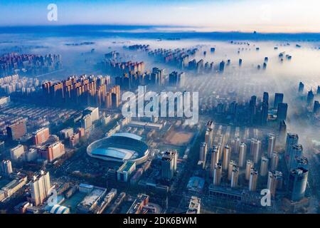 Les nuages d'advection s'écoulent lentement entre les bâtiments urbains, se profilant comme un parc d'expositions dans la ville de Shijiazhuang, province du Hebei au nord de la Chine, 12 décembre Banque D'Images