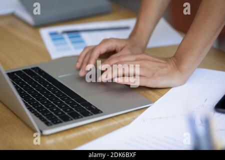 Gros plan sur les mains de la jeune femme designer à l'aide du clavier d'ordinateur portable Banque D'Images