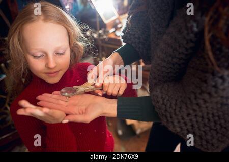 Prism. Cheerful family, mother and kids looking for home decoration and holiday's gifts in household store. Stylish retro things for greetings or design. Interior renovation, celebrating time. Stock Photo