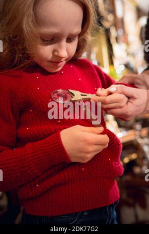 Prism. Cheerful family, mother and kids looking for home decoration and holiday's gifts in household store. Stylish retro things for greetings or design. Interior renovation, celebrating time. Stock Photo