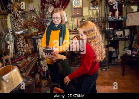 Jouets. Famille, mère et enfant joyeux à la recherche de décoration et de cadeaux de vacances dans le magasin de la maison. Des articles rétro et élégants pour des voeux ou un design. Rénovation intérieure, célébration du temps. Banque D'Images