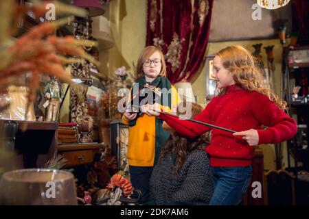 Jouets. Famille, mère et enfant joyeux à la recherche de décoration et de cadeaux de vacances dans le magasin de la maison. Des articles rétro et élégants pour des voeux ou un design. Rénovation intérieure, célébration du temps. Banque D'Images